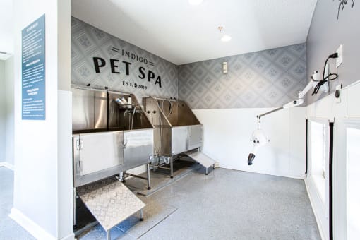 a pet spa room with a large stainless steel machine and a shower