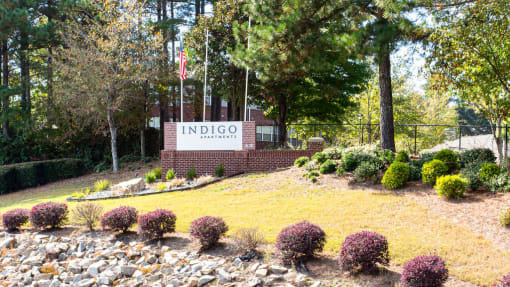 a view of the indio welcome sign in front of a brick building with trees