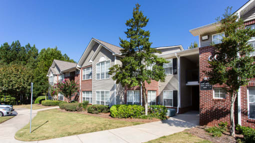 an exterior view of an apartment building with trees in front of it