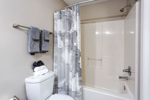 a bathroom with a shower and a toilet and a shower curtain