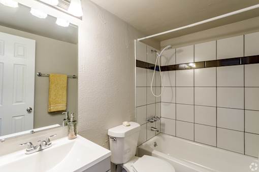 A white bathroom with a toilet, sink, and bathtub.