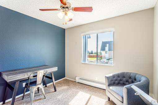 A room with a blue wall and a ceiling fan.