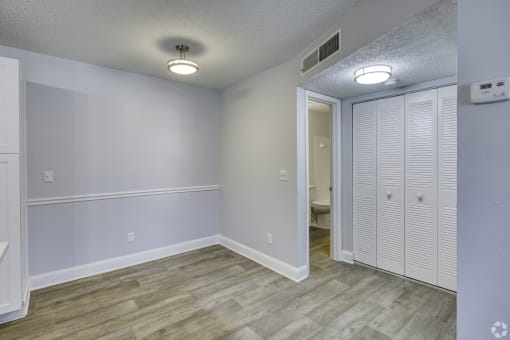 an empty room with white closet doors and a hallway to a bathroom at Beach Club, Tampa, 33614