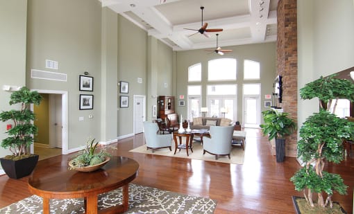 an open concept living room and dining room with green walls and a white coffered ceiling
