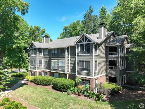 the view of an apartment building with a lawn and trees
