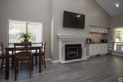 the view of a living room with a fireplace and a table and chairs
