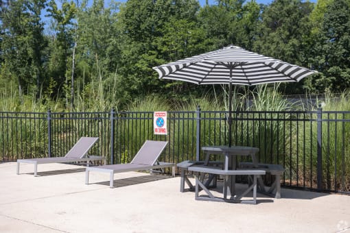 a patio with two chairs and a table with an umbrella