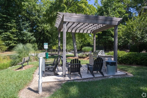 a picnic area with a wooden pavilion and benches