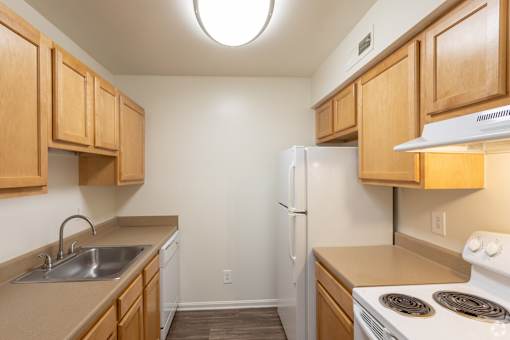 a kitchen with wood cabinets and white appliances