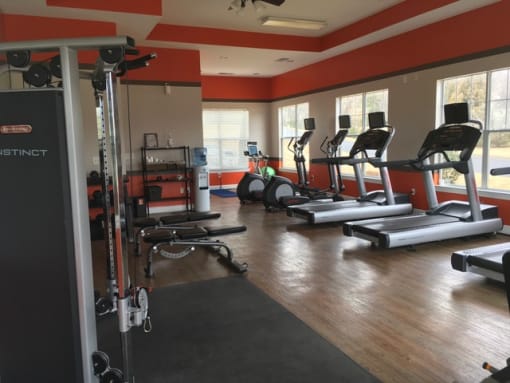 Fitness center with equipment and large windows at the Haven at Knob Creek Apartments Johnson City, TN