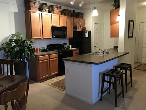 Kitchen with black appliances and island at the Haven at Knob Creek Apartments Johnson City, TN