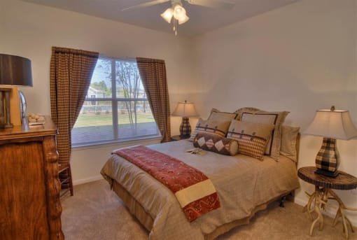 Spacious living room with queen size bed and curtains at the Haven at Knob Creek Apartments Johnson City, TN