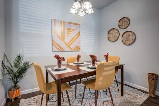 A dining room with a wooden table and chairs.