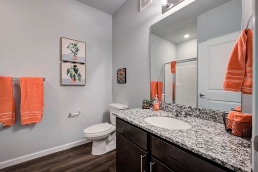 A bathroom with a toilet, sink, and towels.