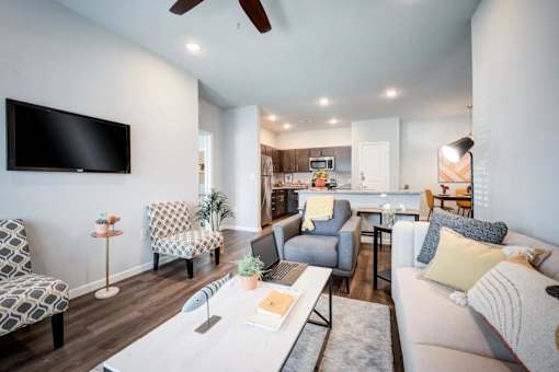 A living room with a television, couches, and a dining table.