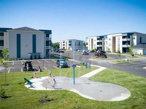 A playground with a blue pole and a white fence.