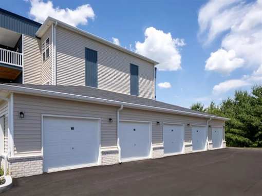 A row of garage doors are on the side of a building.
