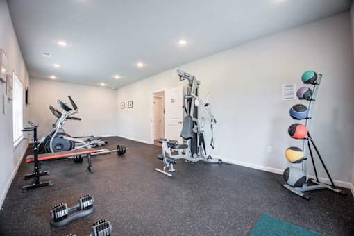 A gym with a variety of equipment including weights and exercise machines.