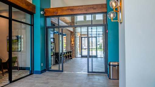 A blue wall with a wooden beam above a glass door.