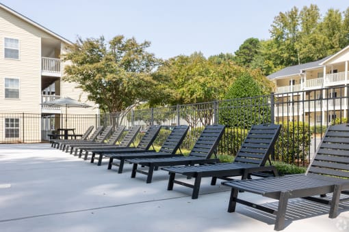 a row of lounge chairs in front of an apartment building