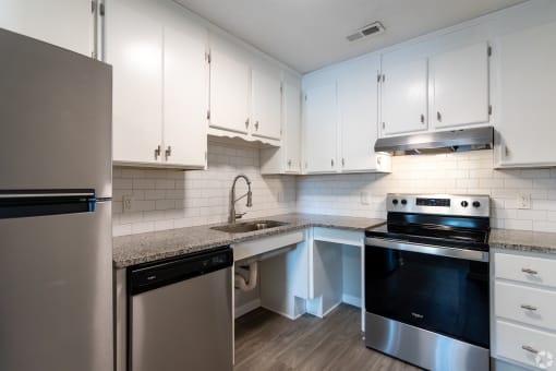a kitchen with white cabinets and stainless steel appliances