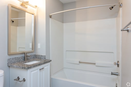 a bathroom with a sink and a tub and a mirror
