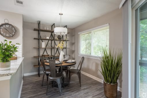 a dining room with a table and chairs and a clock on the wall