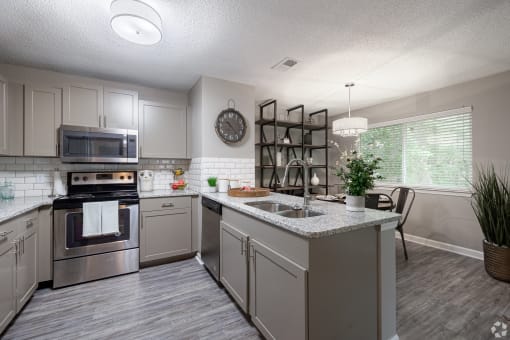 an open kitchen with stainless steel appliances and granite counter tops