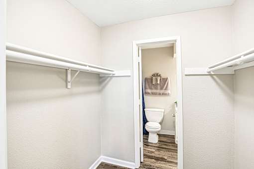 A white bathroom with a toilet and a shower curtain.