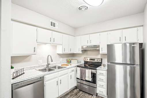 A kitchen with white cabinets and stainless steel appliances.
