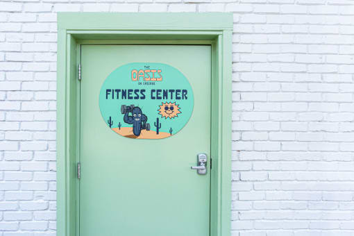 a green door with a sign that says the oasis fitness center
