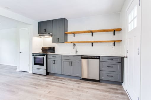 a kitchen with gray cabinets and white walls