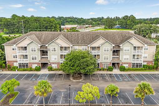 A large apartment complex with a parking lot in front.