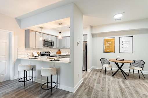 A kitchen with a bar stool and a table with chairs.