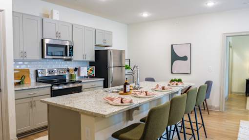 A kitchen with a table and chairs set for a meal.