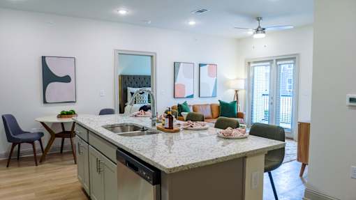 A kitchen with a table and chairs and a counter with food on it.