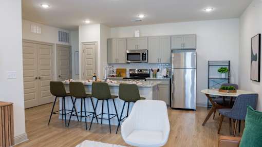 A modern kitchen with a dining table set for four.