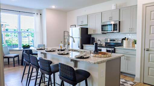 A kitchen with a bar area and chairs.