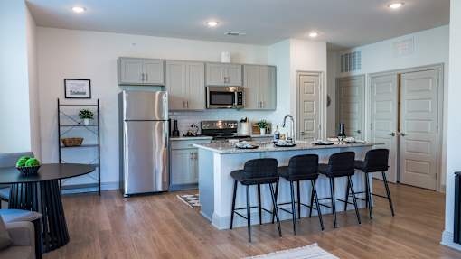 A modern kitchen with a large island and bar stools.