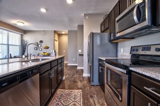 a kitchen with dark cabinets and stainless steel appliances at Park 33, Goshen Indiana