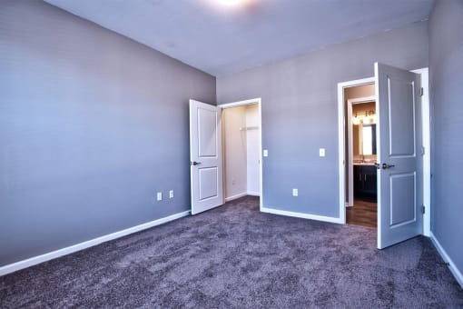 a bedroom with a carpeted floor and a door leading to a bathroom at Park 33, Goshen, IN 46526