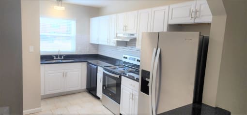 a kitchen with white cabinets and a refrigerator at Savan Pointe Townhomes East and West, Georgia