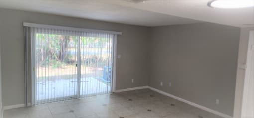 an empty living room with a sliding glass door to a patio at Savan Pointe Townhomes East and West, Savannah Georgia
