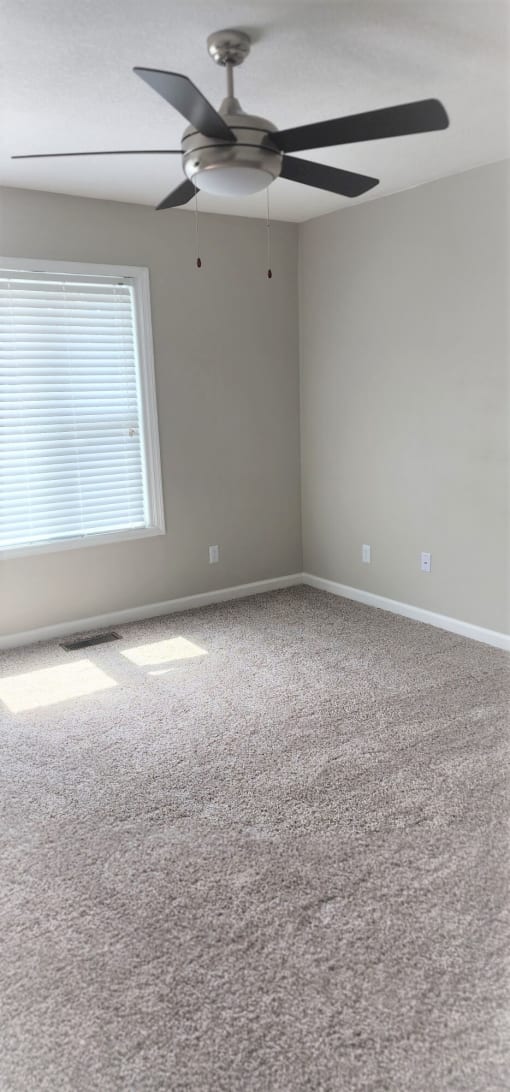 an empty room with a ceiling fan and a window at Savan Pointe Townhomes East and West, Savannah Georgia