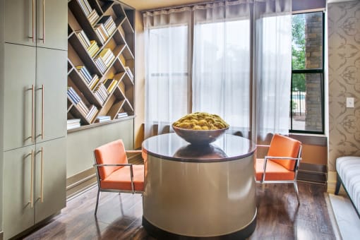 a dining room with a glass table and orange chairs