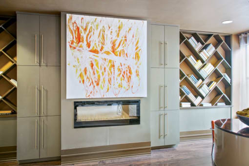 a painting hangs above a fireplace in a living room