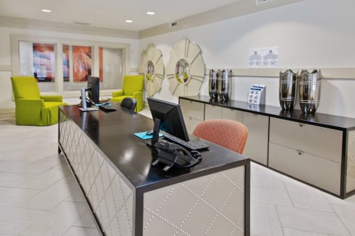 the lobby of a hotel with a computer desk and chairs