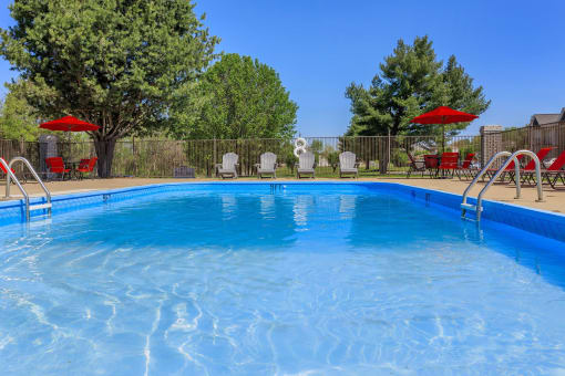 a swimming pool with chairs and umbrellas next to a resort style pool at The Dylan, Murfreesboro, 37129