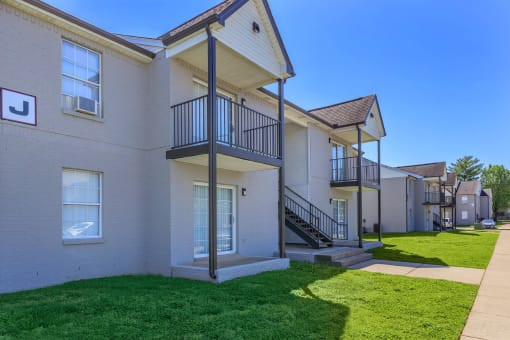 a row of white houses with a yard and grass at The Dylan, Murfreesboro
