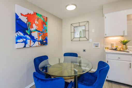 a dining room with a glass table and blue chairs at The Dylan, Murfreesboro, TN